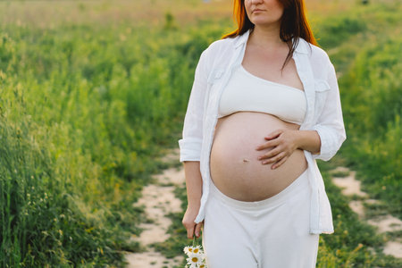 Pregnant woman in a field. Expecting joyful moments