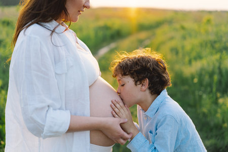 A pregnant woman enjoys peaceful moment in nature with her son