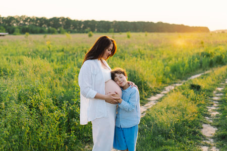 A pregnant woman enjoys peaceful moment in nature with her son