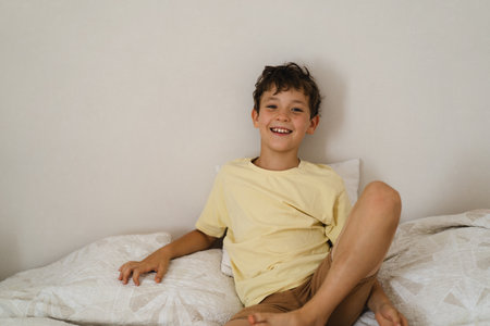 Happy child smiling while sitting on a bed