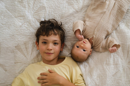 Two brothers enjoying playing in cozy bright bedroom