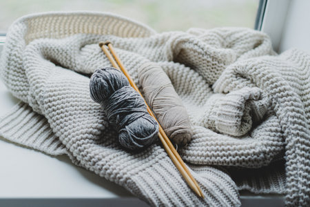 Knitting materials and soft yarn on a cozy blanket in a warm indoor settingの写真素材