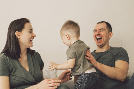 Family Love. Parents and Little Son, Having Fun Together At Home In Bed Room.