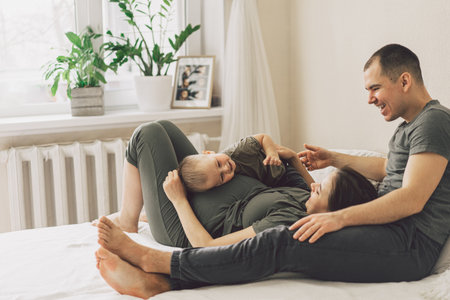 Family Love. Parents and Little Son, Having Fun Together At Home In Bed Room.の写真素材
