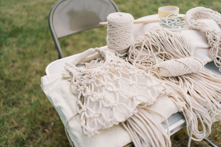 Woman knits bag using macrame technique outdoors near tents. Outdoor hobbies.の写真素材