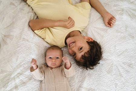 Two brothers enjoying playing in cozy bright bedroomの写真素材