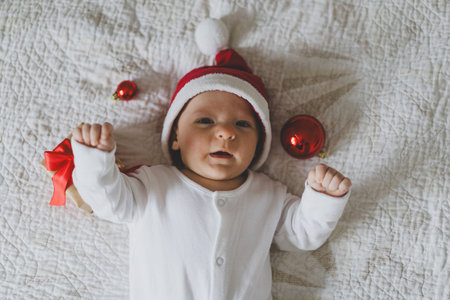 Cute baby in Santa hat with holiday decorations and gifts during Christmas seasonの写真素材