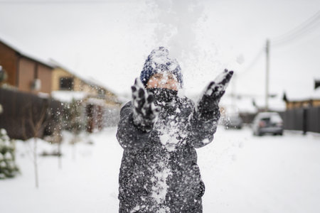 Happy Smiling Boy Plaind in Snow on Winter Day
