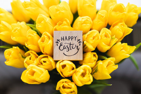 Spring festive composition with yellow tulips and decorative eggsの写真素材