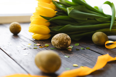 Spring festive composition with yellow tulips and decorative eggs. Easter holiday