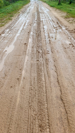 A dirty country road. After the rain, puddles, mud and traces of the car tires were formed. Shot on a phoneの写真素材