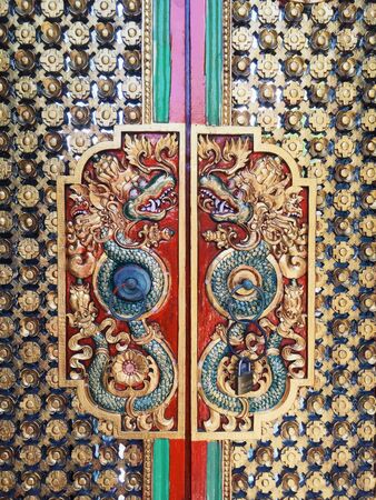 Carved and brightly painted mythological figure on the door, Bali Indonesiaの写真素材