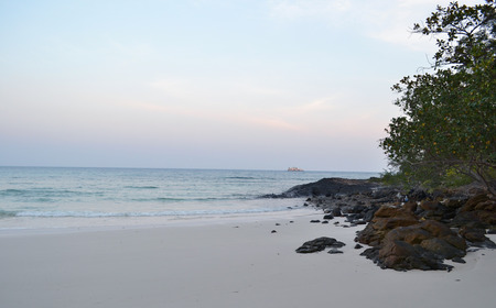 Sunset on the beach. Scenic orange tones of the sky, dark water, sand, relax and quietness. Imagine that you are alone on the whole bayshore. Photo made in Thailand, Asia.の写真素材
