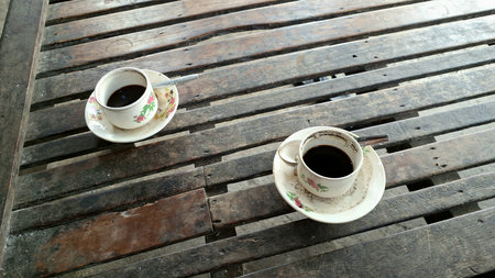 Cup of Black Coffee on Rustic Wooden Table: Simple Coffee Mug and Saucer on a Textured Wood Surface, Morning Drinkの写真素材