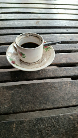 Cup of Black Coffee on Rustic Wooden Table: Simple Coffee Mug and Saucer on a Textured Wood Surface, Morning Drinkの写真素材