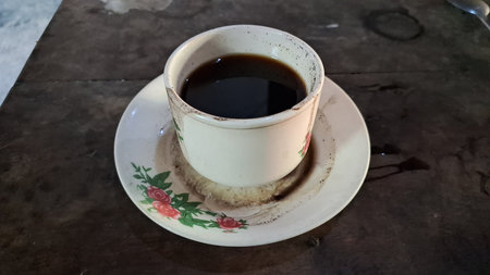 Coffee Cup on Wooden Surface: Basic Mug with Dark Coffee on a Rustic Tabletop, Simple Beverage Still Lifeの写真素材