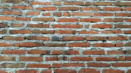 Rough-Hewn Red Brick Wall Texture, Close-Up Detail Emphasizing the Material's Strength and Durability for Construction or Industrial Themed Visualsの写真素材