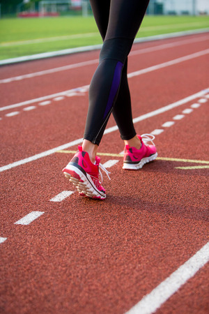 Girl's legs in leggings and pink running shoes on a stage.の写真素材