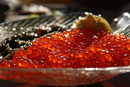 It is a lot of red and black caviar in a plate on a table.の写真素材