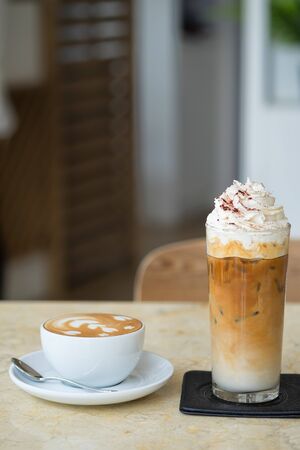 Ice and hot coffee on white tableの写真素材