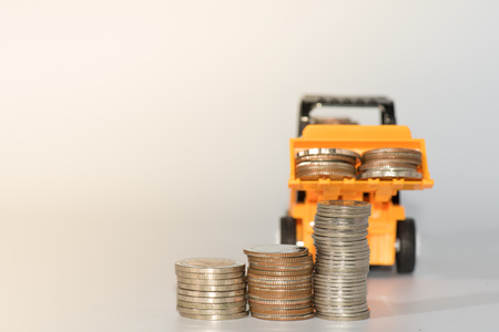 bulldozer toy and coins ,concept idea for save money and business.の写真素材