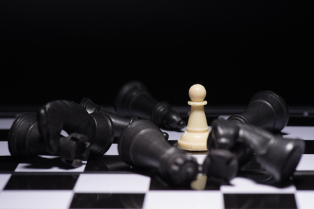 One  chess pieces staying against black chess piecesの写真素材