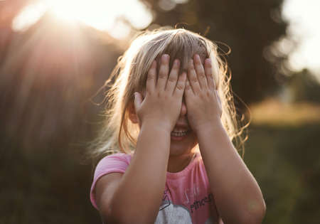A happy child plays summer in the village at sunsetの写真素材