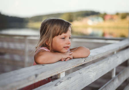 A happy child plays summer in the village at sunset