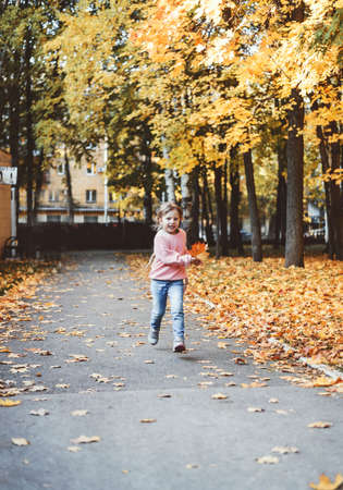 A child plays with leaves in autumnの写真素材