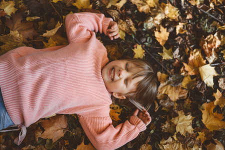 A child plays with leaves in autumnの写真素材
