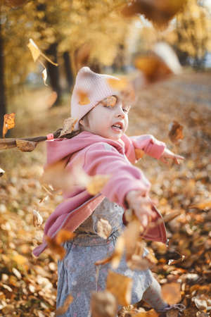 A child plays with leaves in autumnの写真素材
