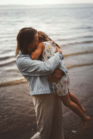 Mom and daughter play summer on the beachの写真素材