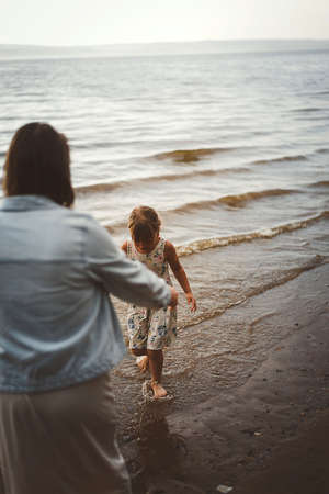 Mom and daughter play summer on the beachの写真素材