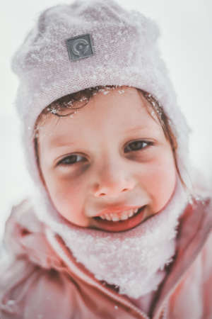 A small child plays snow games in nature in winterの写真素材