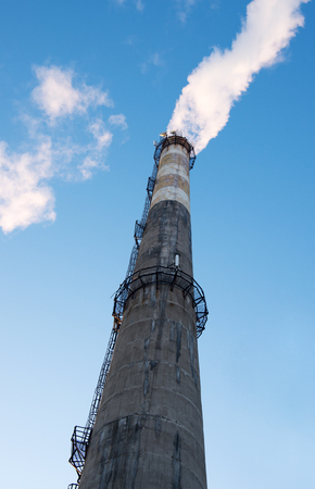 Smoke from a chimney on blue sky backgroundの写真素材