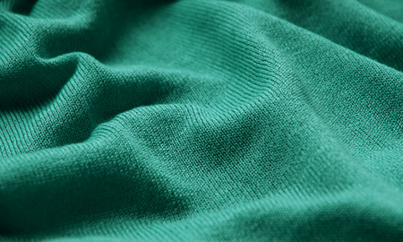 The texture of a knitted woolen fabric green.の写真素材