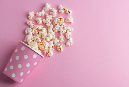 Spilled popcorn on a pink backgroundの写真素材