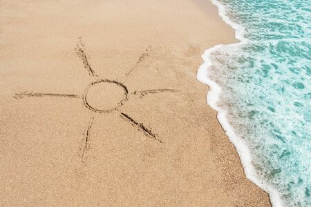 The symbol of the sun drawing on the sand.の写真素材