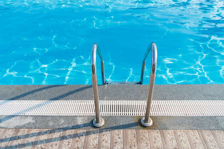 Grab bars ladder in the blue swimming poolの写真素材