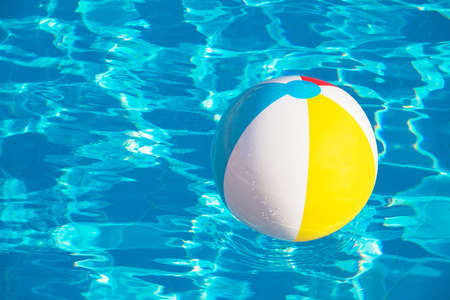 Colorful inflatable ball floating in swimming poolの写真素材