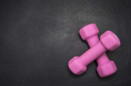 Two pink dumbbell on a gray backgroundの写真素材