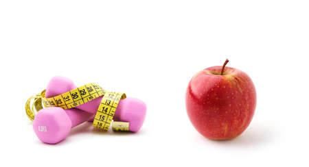 Two pink dumbbells and red apple in a white backgroundの写真素材