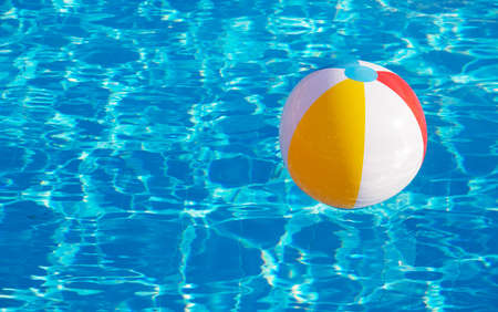 Colorful inflatable ball floating in swimming poolの写真素材