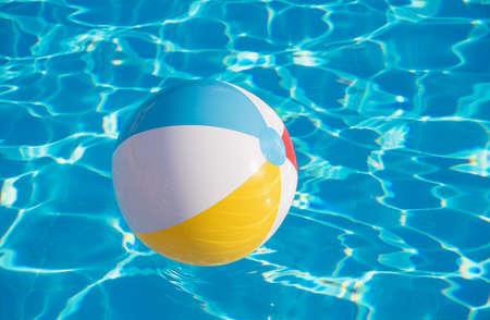 Colorful inflatable ball floating in swimming poolの写真素材