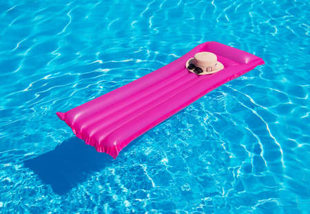 Beach summer holiday background. Inflatable air mattress and hat on swimming pool .;の写真素材