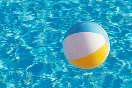 Colorful inflatable ball floating in swimming poolの写真素材