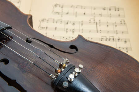 Old violin lying on the sheet of music, music conceptの写真素材