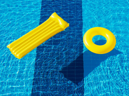 floating ring and a mattress on the blue water of the poolの写真素材