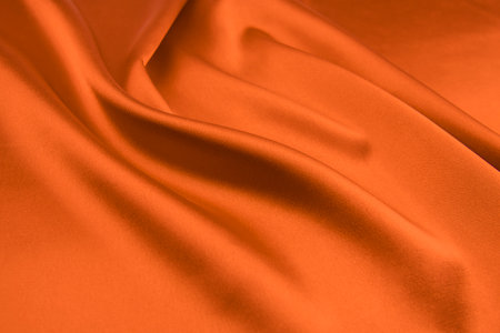 Smooth elegant orange silk can be used as backgroundの写真素材