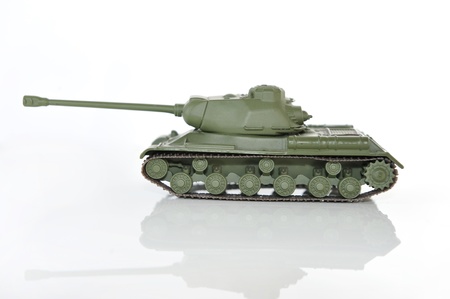 Green toy tank on  white background with reflection 